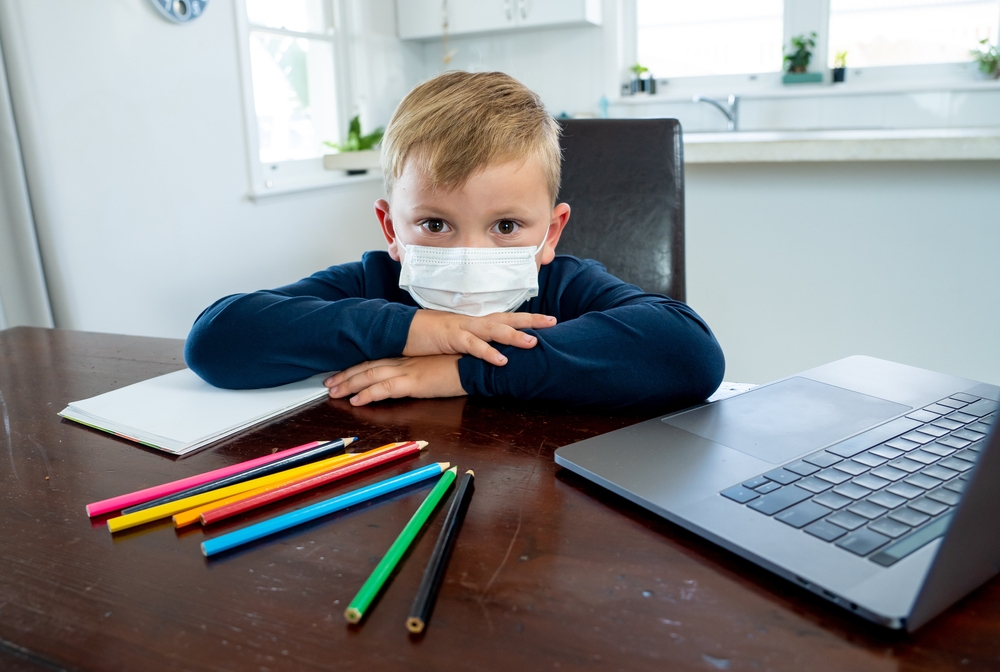 Child at laptop with mask